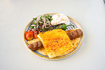 Grilled Turkish Adana, Urfa  Kebab with grilled vegetables, onion and rice on plate. Adana durum, Urfa durum .
