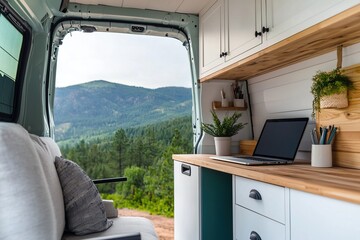 Fototapeta premium Balancing Freedom and Flexibility with Remote Work. A cozy van interior featuring a workspace, a laptop, and a scenic mountain view through the open door.