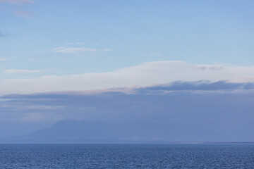 Serene Ocean View with Distant Hills Under a Clear Blue Sky