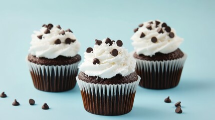 Homemade chocolate cupcakes topped with creamy coconut and chocolate chips on a blue background perfect for holiday dessert celebrations