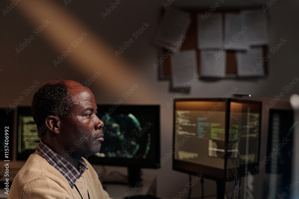 Aufkleber serious mature man in beige sweater sitting in dark office and looking at computer screen while deco