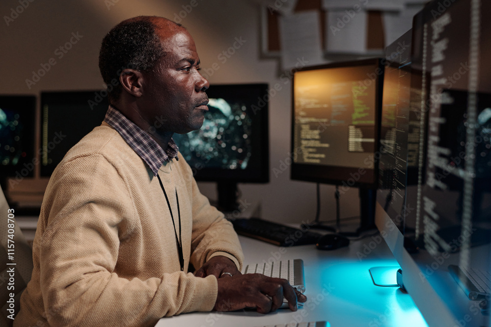 Poster Serious male IT engineer keeping hand on computer mouse and looking at screen while developing new software in office