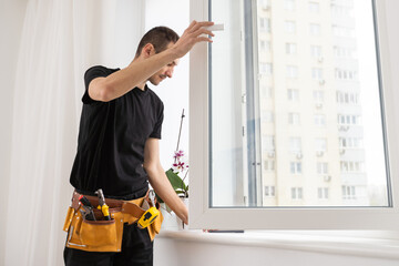 Construction worker installing new window in house