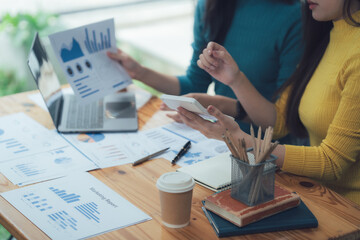 Fototapeta premium Strategic Collaboration: Two businesswomen meticulously analyze financial data, showcasing a synergy of expertise and a shared vision for success. 