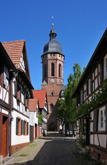 Fototapeta premium Quaint little alley with half-timbered houses and church tower in the old town of Kandel, Pfalz region in Germany