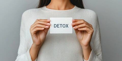 Woman holds detox card representing health and rejuvenation concepts in modern lifestyle