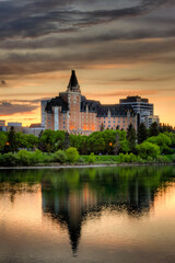 A large building with a tower is reflected in the water