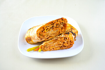 Lavash doner kebab ( soslu kasarli zurna doner durum )  or shawarma sliced in plate isolated.  Tavuk Et Doner Durum. Hatay Iskenderun usulu bazuka tavuk doner durum.