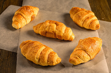 Golden croissants arranged on parchment paper