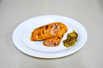 Lavash doner kebab ( soslu kasarli zurna doner durum )  or shawarma sliced in plate isolated.  Tavuk Et Doner Durum. Hatay Iskenderun usulu bazuka tavuk doner durum.