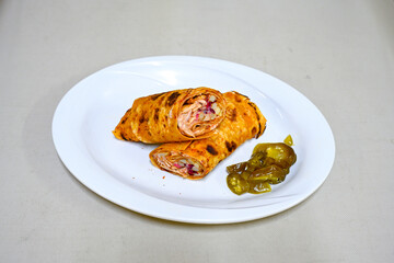 Lavash doner kebab ( soslu kasarli zurna doner durum )  or shawarma sliced in plate isolated.  Tavuk Et Doner Durum. Hatay Iskenderun usulu bazuka tavuk doner durum.