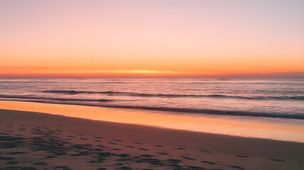 A photo of a sunrise at a beach. The sky is painted with warm hues of orange and pink.