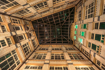 An impressive atrium view with large windows, a glass roof and green light accents in a harmonious, earthy design.