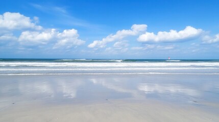 Obraz premium Serene Coastal View with Reflections on Wet Sand and Blue Sky