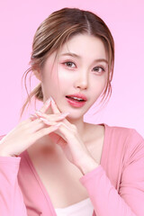 Portrait of a Smiling Asian Woman fresh skin in Stylish Pink Attire Against a Soft Background.