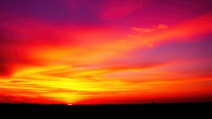 Fototapeta premium Fiery Sunset Hues Paint the Evening Sky with Vivid Colors