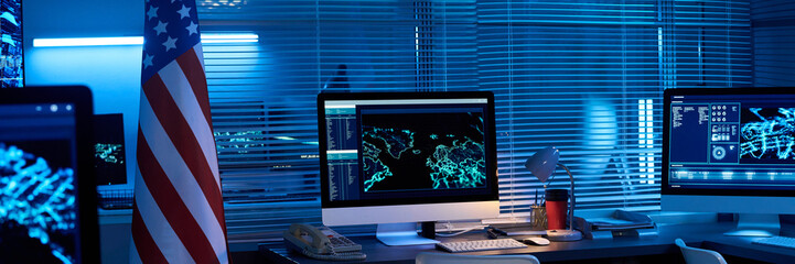 Header of American flag standing in spacious military command center with several workplaces with...