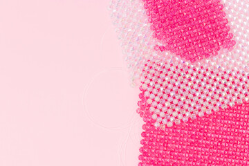Details for handcraft bag made from acrylic beads on a pink background. Place for text.
