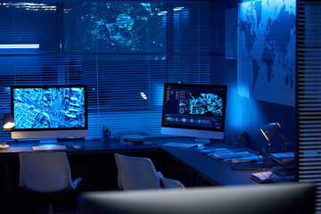Workplace of security officers with group of computer monitors with graphic data on screens in...
