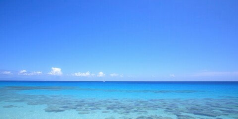 Obraz premium Serene Coastal Landscape Featuring Crystal Clear Water and Vibrant Blue Sky, Ideal for Travel, Vacation, and Nature Themes in Stock Photography Collections