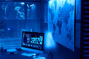 Map hanging on wall of military command center with computer monitor standing on workplace of...