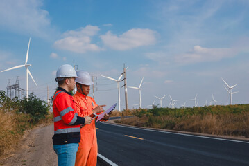 Engineer and technician are working together to plan serious repairs on wind turbines to store backup power for use when needed.