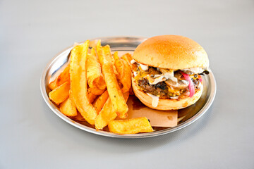Big tasty burger with beef cutlet on a plate. Hamburger, cheeseburger with mushroom. Hamburger, Mexica, mushroom double cheddar  burger.  Crispy chicken burger. With french fries, patates kizartmasi.