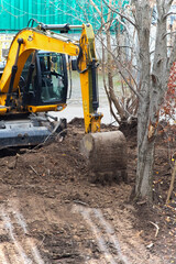 Fototapeta premium A powerful excavator digs deep into the ground, creating a pit for the future foundation.