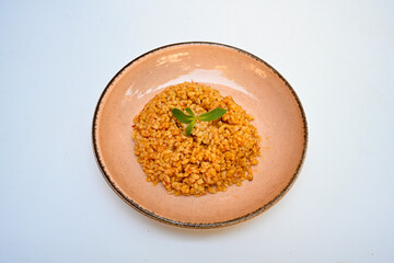 Traditional turkish bulgur pilaf with tomato sause in plate (Turkish name; bulgur pilavi, meyhane...