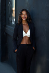 Fototapeta premium Beautiful young adult businesswoman in a stylish outfit standing confidently outside in an urban setting during daylight