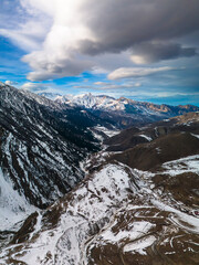 Beautiful aerial view of snowy peaks in a picturesque gorge. Landscape and nature of the North Caucasus