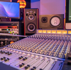 professional audio mixing console with studio monitors and equipment in the background, ideal for...