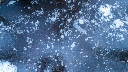 Ice texture background. Textured cold frosty surface with frozen air bubbles of ice on a dark background.