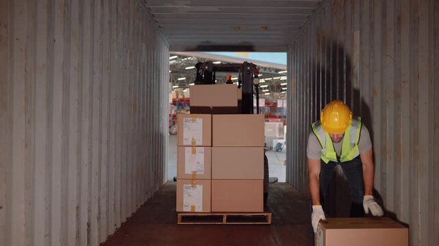 Workers load boxes of goods into containers at a distribution center.

