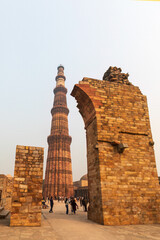 Fototapeta premium New Delhi, India December 20, 2024: Aibak’s 72.5 mts. tall - Qutb Minar happens to be the tallest minaret in the world built of bricks, bears the rich testimony of early Afghan architecture. 