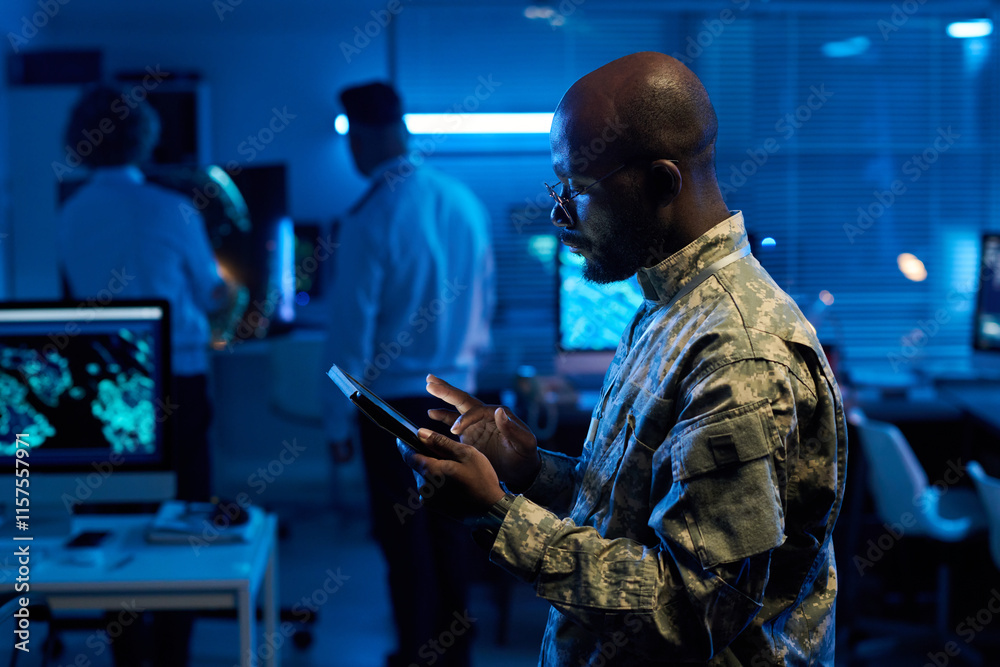 Aufkleber side view of african american male officer in camouflage uniform scrolling through online data on ta