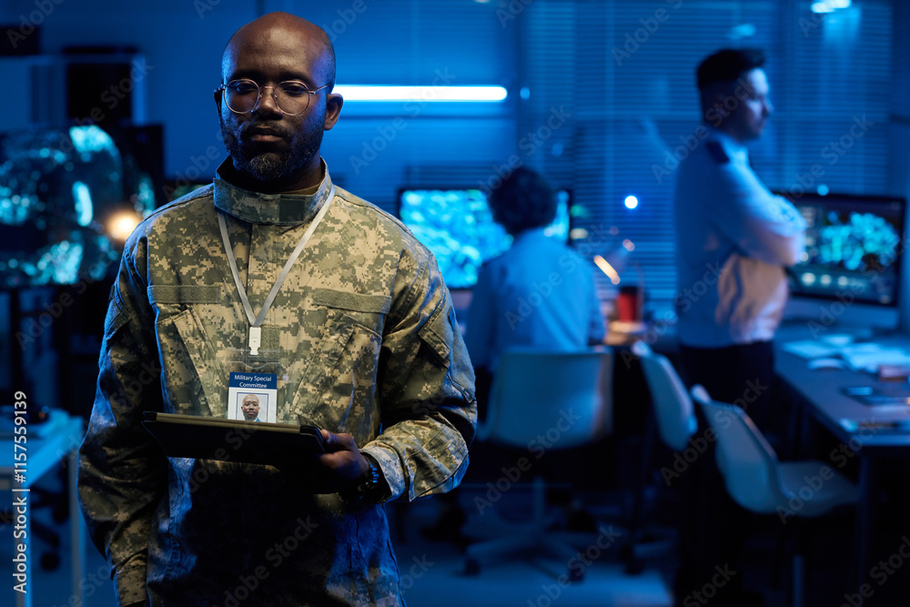 Aufkleber serious young man in uniform and eyeglasses looking tablet in hand and looking through online data o