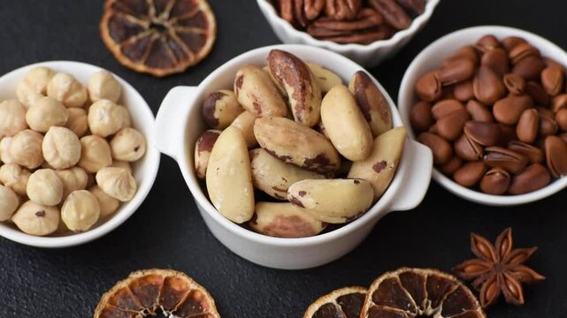 Delicious nutritious brazil nuts in ceramic bowl on dark concrete background