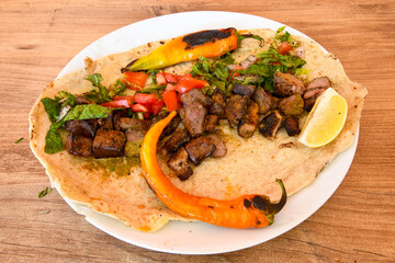 Famous Urfa meat liver, ciger wrapped by lavash with roasted chili pepper, onion and sauce in Sanliurfa, Turkey. Kuzu et ciger sis. Izgara dana bonfile, cop sis, kuzu pirzola. Karisik kebap, beyti keb