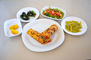 Lavash doner kebab ( soslu kasarli zurna doner durum )  or shawarma sliced in plate isolated.  Tavuk Et Doner Durum. Hatay Iskenderun usulu bazuka tavuk doner durum.