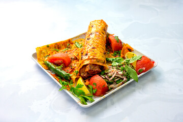 Lavash doner kebab ( soslu kasarli zurna doner durum )  or shawarma sliced in plate isolated.  Tavuk Et Doner Durum. Hatay Iskenderun usulu bazuka tavuk doner durum.