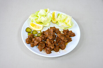 Cig kofte (raw meatball) with lettuce, tomato, pickle and lemon, hot Chee kofta. Turkish local raw food concept.Table scene of assorted take out or delivery foods. Doritoslu duble cig kofte durum.