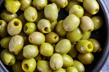 Pitted and marinated green olives in bowl