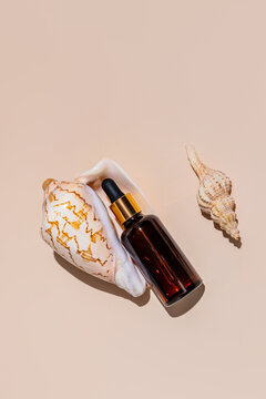 Natural skincare concept with amber dropper bottle and seashells