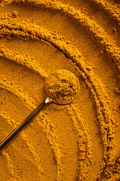Vibrant Curry Powder Close-Up with Textured Swirl Patterns