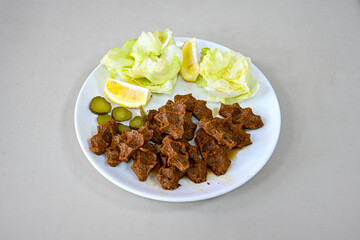 Cig kofte (raw meatball) with lettuce, tomato, pickle and lemon, hot Chee kofta. Turkish local raw food concept.Table scene of assorted take out or delivery foods. Doritoslu duble cig kofte durum.
