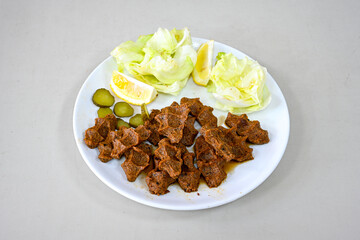 Cig kofte (raw meatball) with lettuce, tomato, pickle and lemon, hot Chee kofta. Turkish local raw food concept.Table scene of assorted take out or delivery foods. Doritoslu duble cig kofte durum.