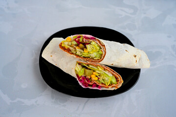 Cig kofte (raw meatball) with lettuce, tomato, pickle and lemon, hot Chee kofta. Turkish local raw food concept.Table scene of assorted take out or delivery foods. Doritoslu duble cig kofte durum.