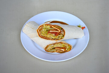 Cig kofte (raw meatball) with lettuce, tomato, pickle and lemon, hot Chee kofta. Turkish local raw food concept.Table scene of assorted take out or delivery foods. Doritoslu duble cig kofte durum.