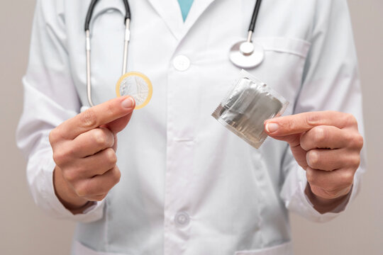 Close up of Doctor holding a condom and its package promoting safe sex and pregnancy prevention